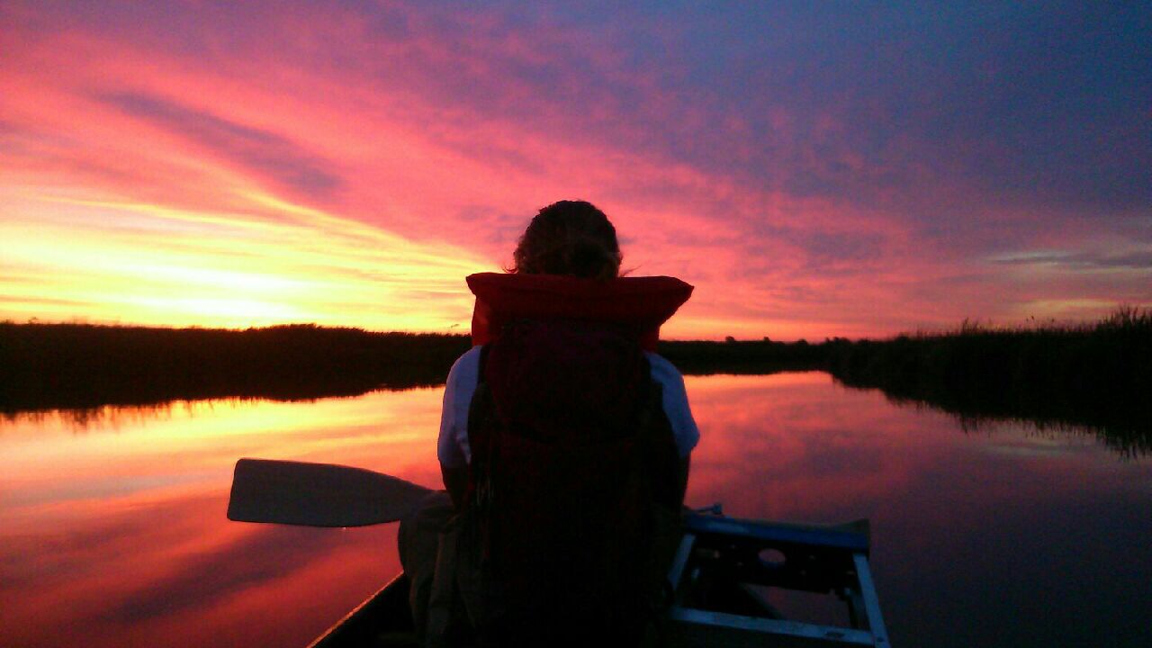 Canoe in sunset. End of image description