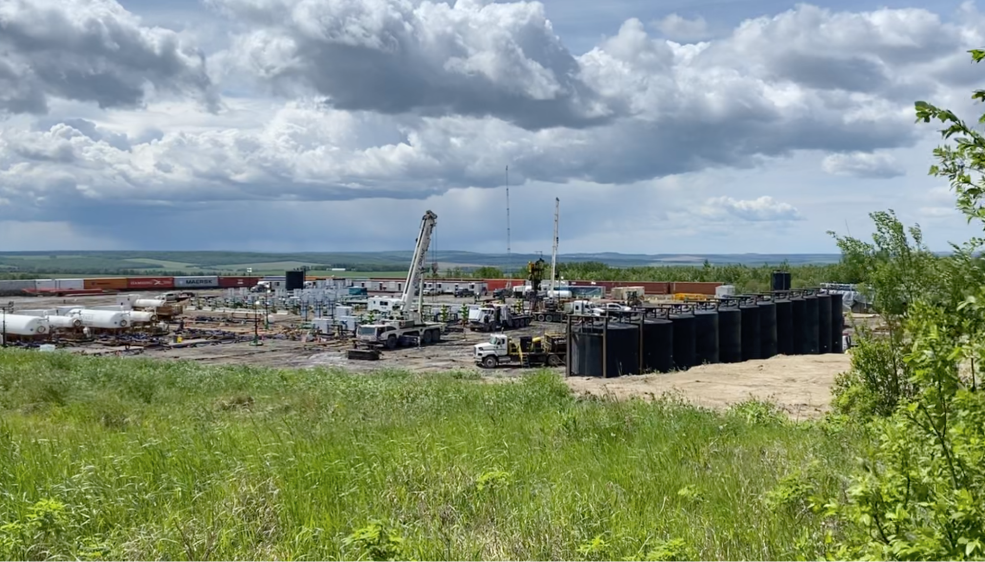 A fracked gas drill site set in a beautiful landscape. End of image description.