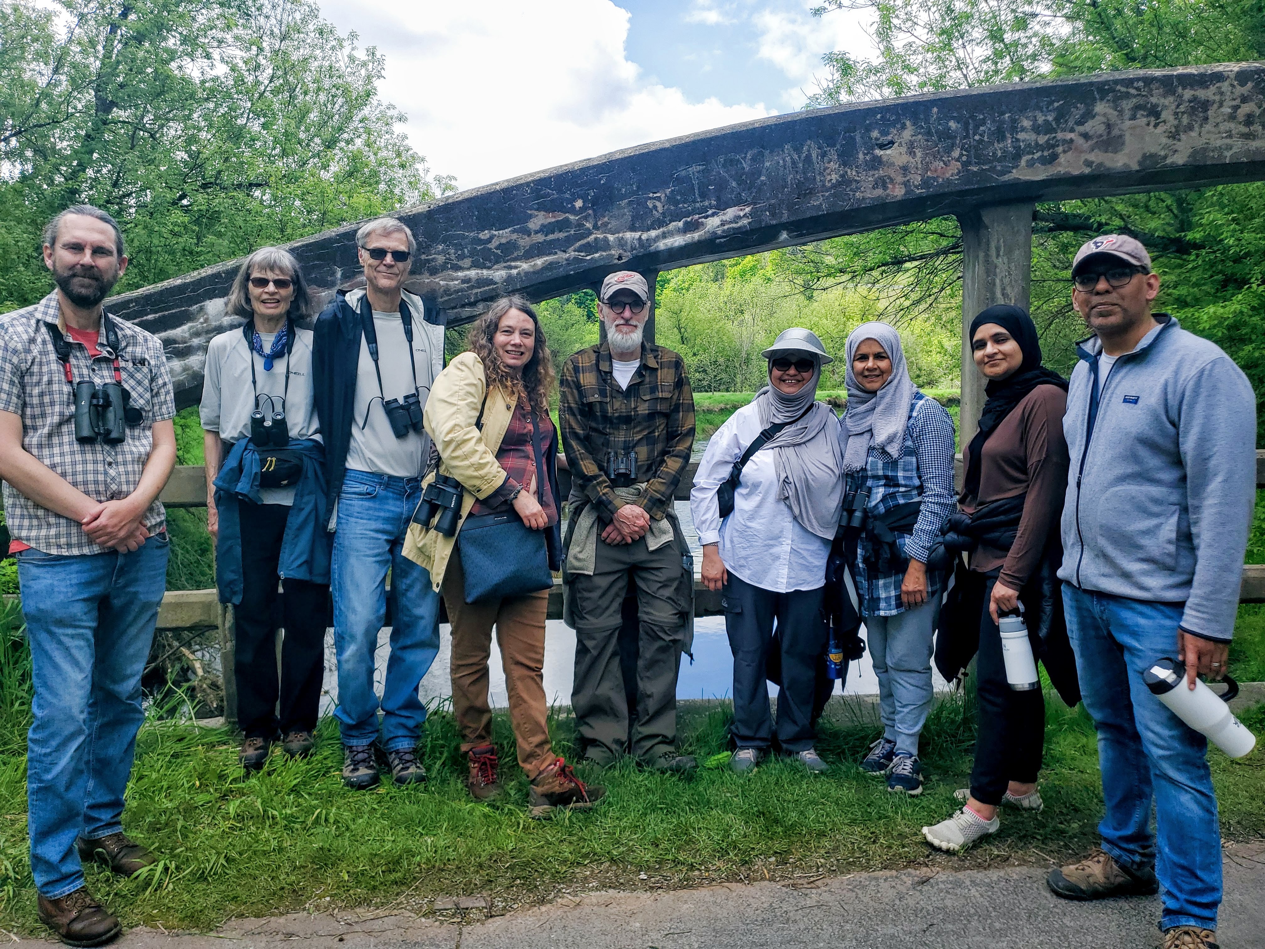 A group with binoculars in a forested area. end of image description.