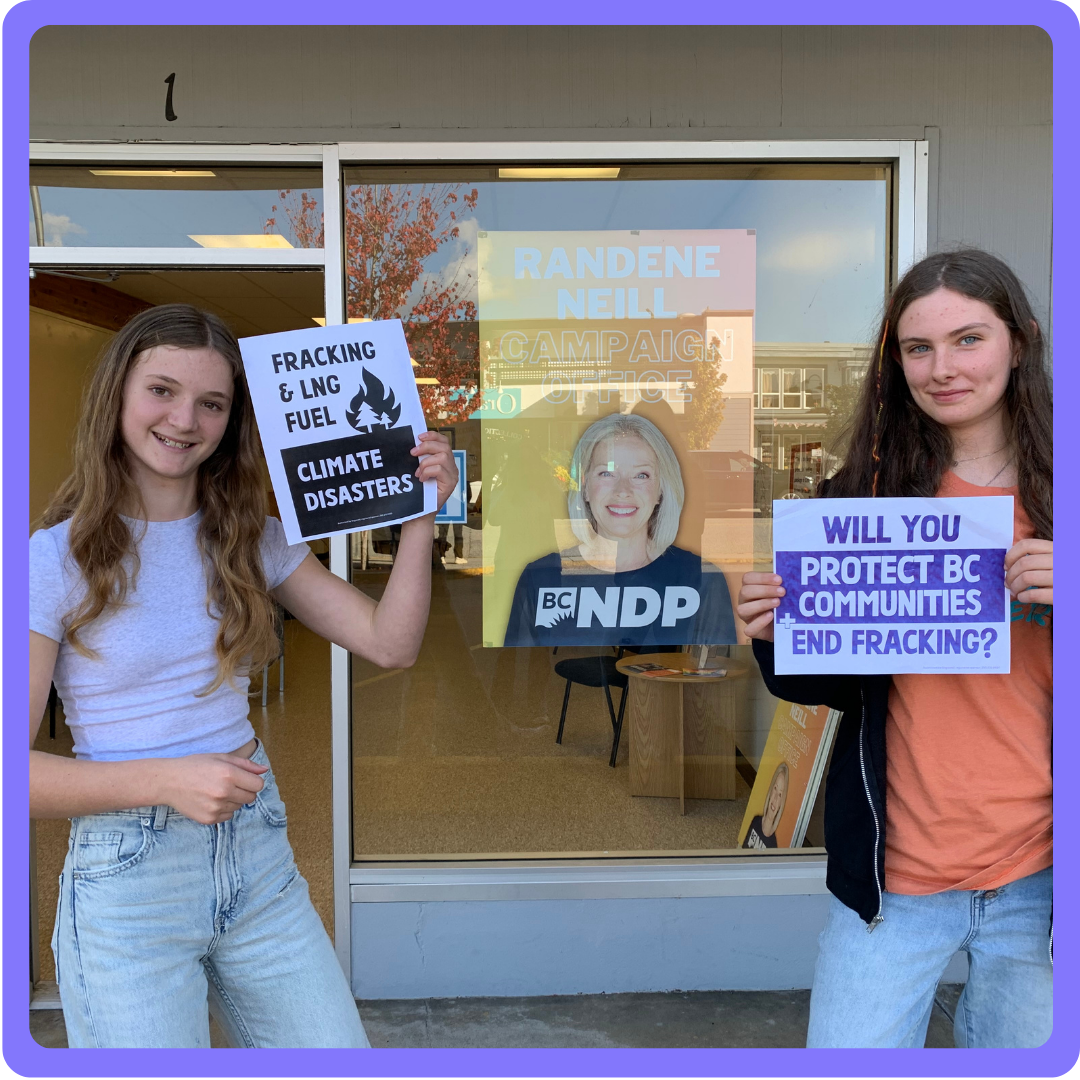 Two activists protesting with banners. end of image description.