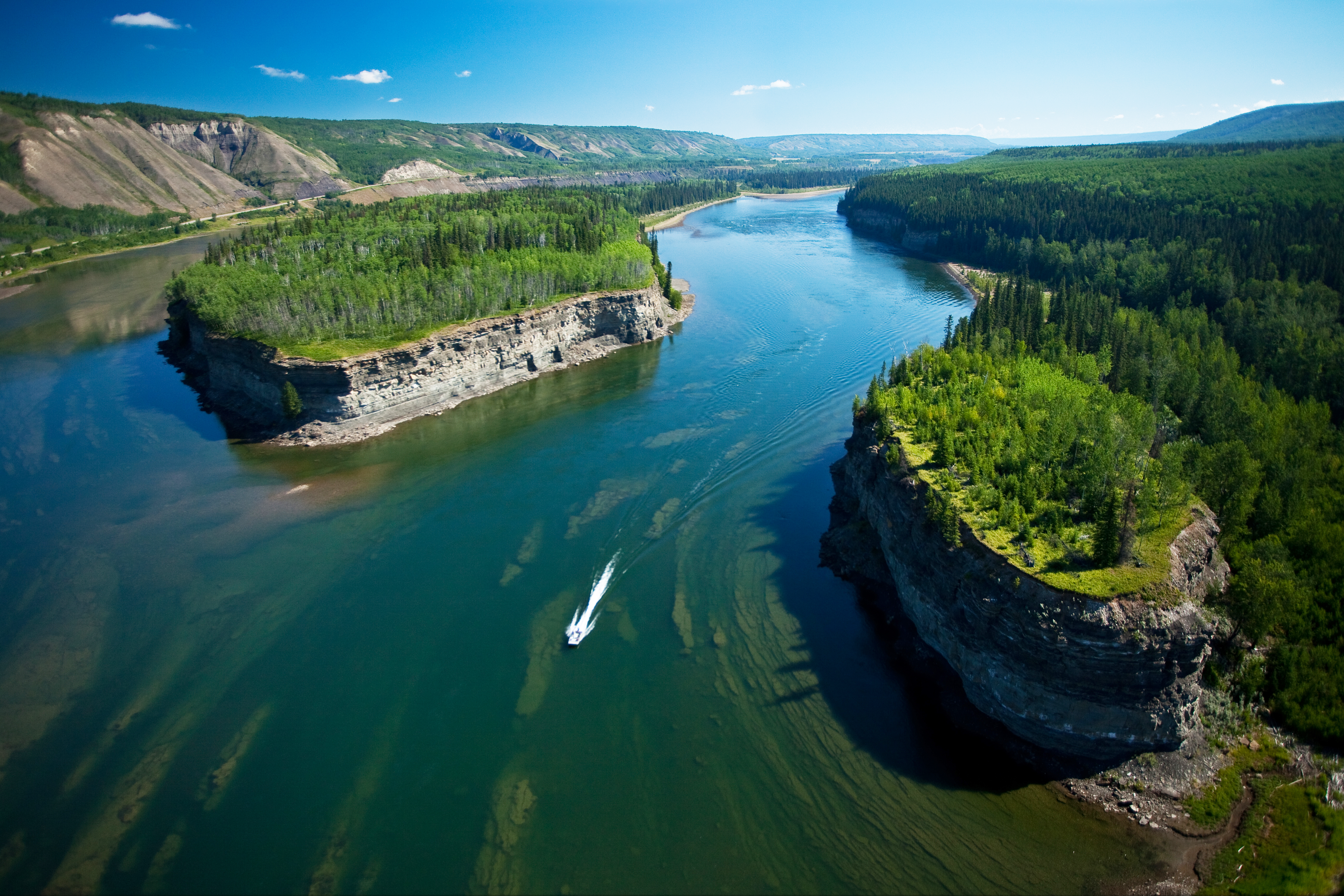 The peace river, with several islands and mountains on either side. End of image description.