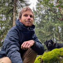 A photo Michael in an old-growth forest with his dog. 