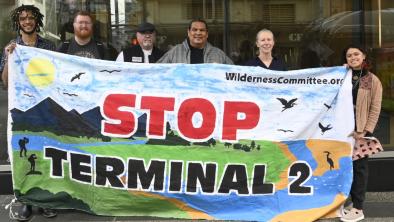 A group of people holding a banner that says "Stop Terminal 2". End of image description.
