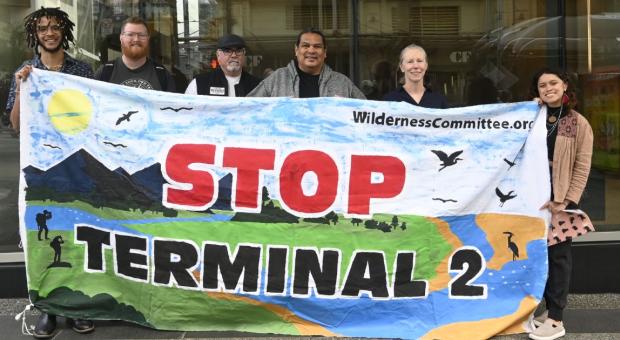 A group of people holding a banner that says "Stop Terminal 2". End of image description.
